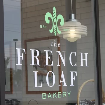 Close up of The French Loaf logo on store window.
